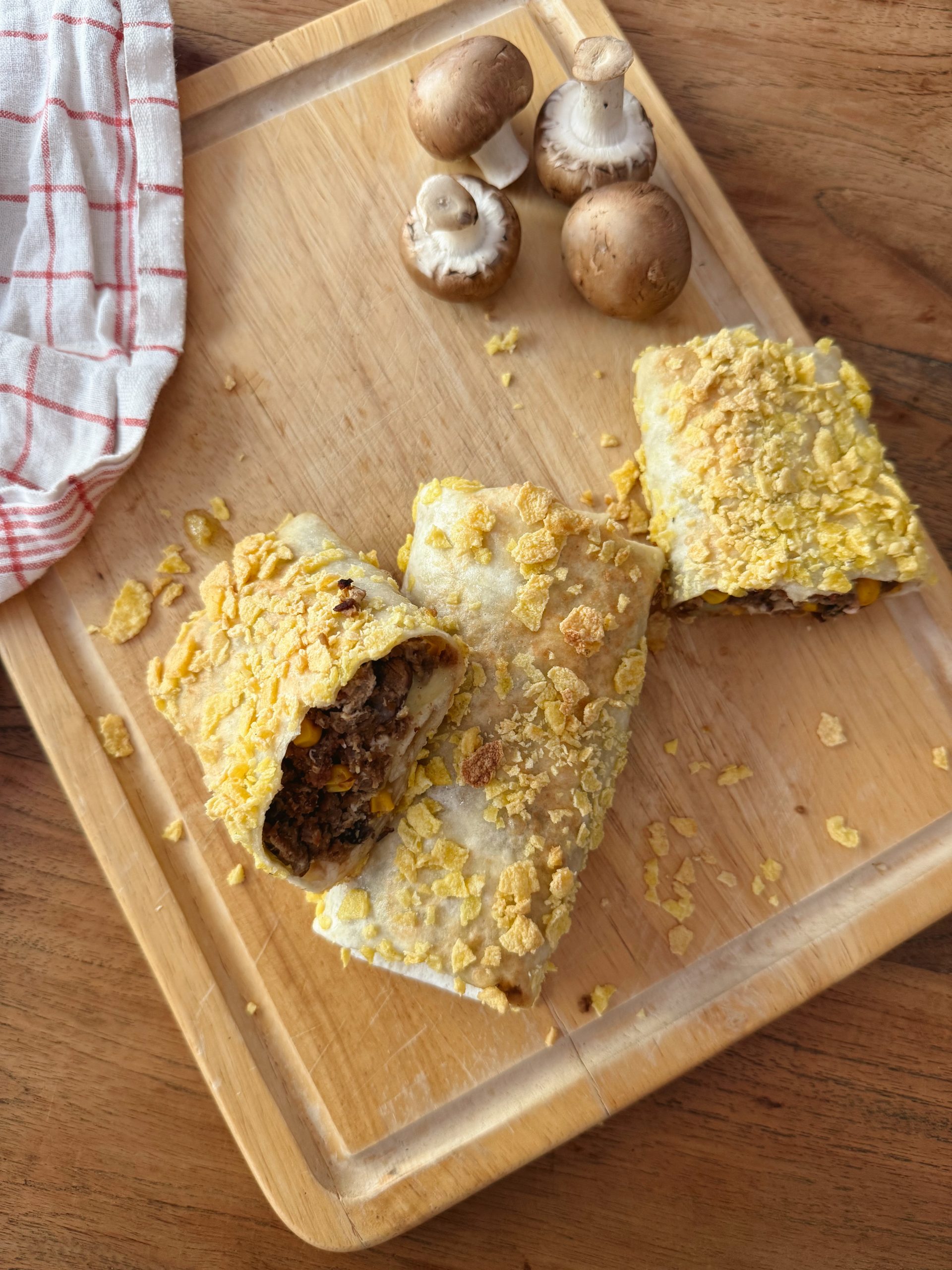Cheesy Burritos mit knuspriger Cornflakes-Panade auf Teller serviert
