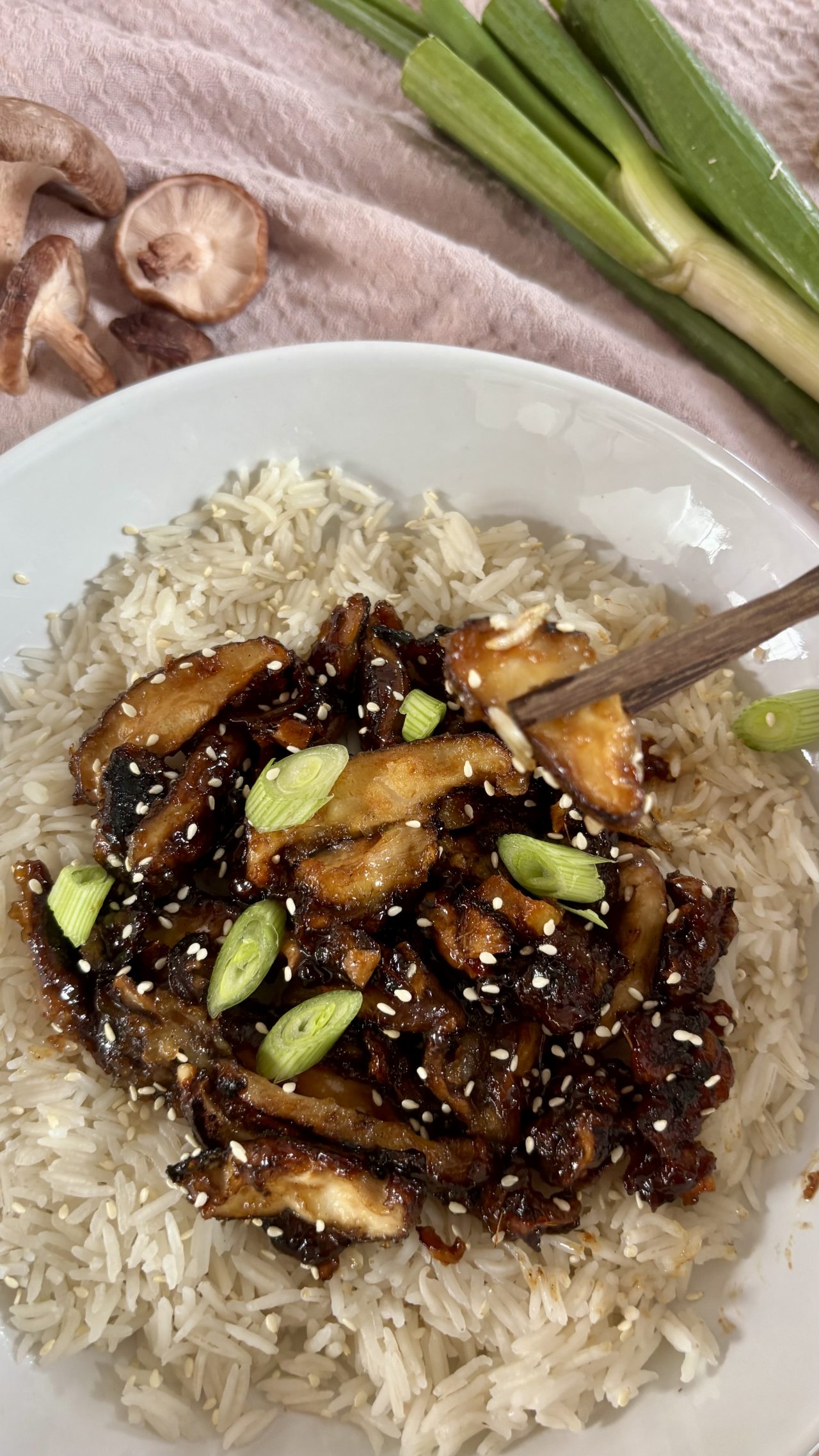 Sticky Shiitake mit Reis serviert und Sesam und Frühlingszwiebeln getoppt.