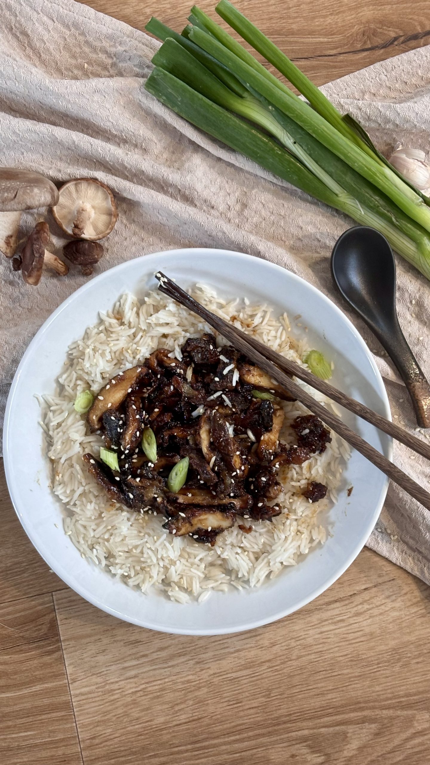 Sticky Shiitake mit Reis serviert und Sesam und Frühlingszwiebeln getoppt.