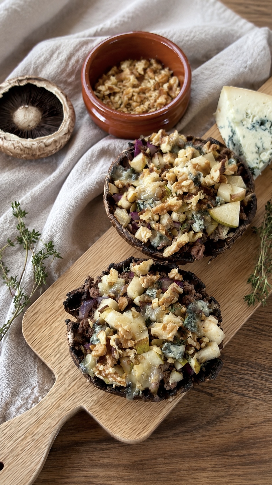 Gefüllte Portobellos mit Hackfleisch, Birne, Walnüssen und Gorgonzola in einer Auflaufform.