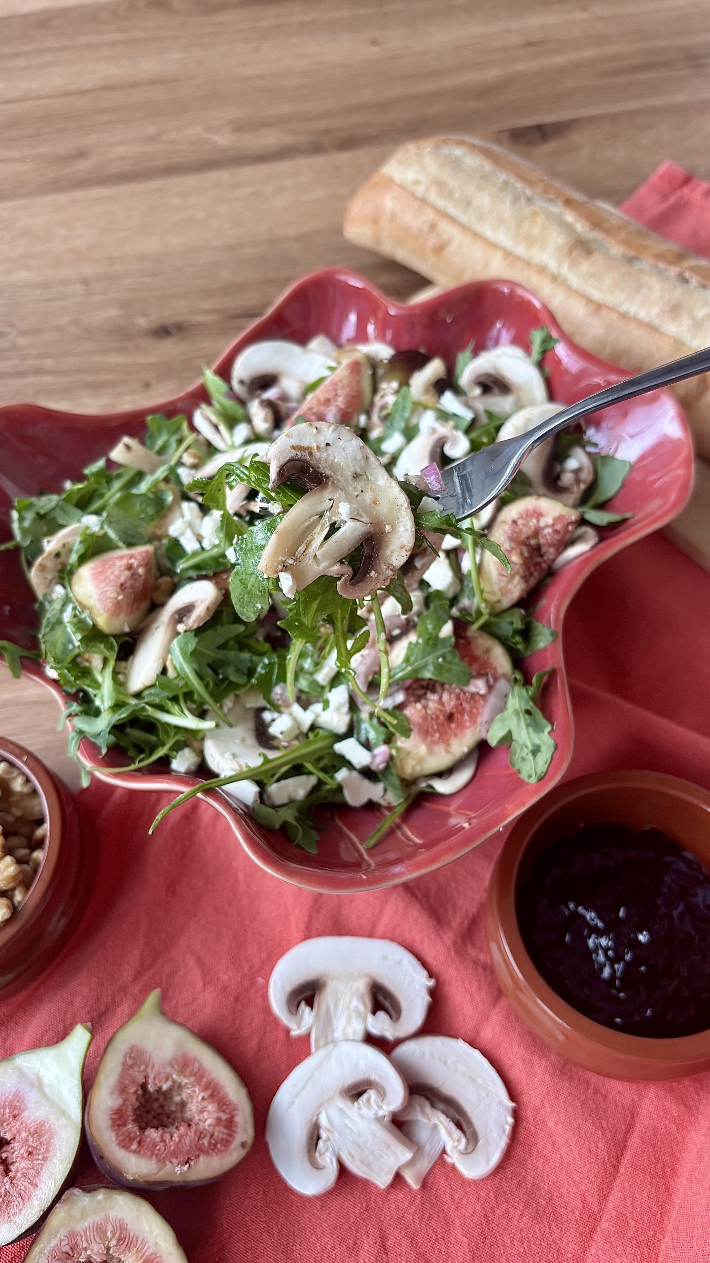 Rucola-Salat mit dünn geschnittenen Champignons, Feigen, Ziegenkäse und Walnüssen.