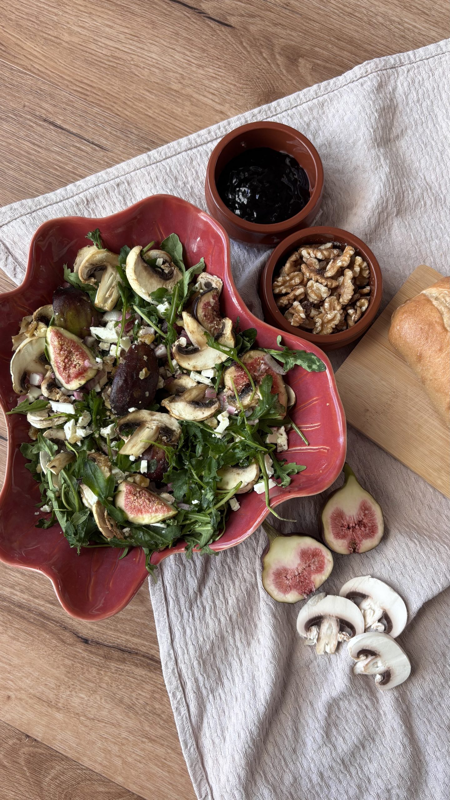 Rucola-Salat mit dünn geschnittenen Champignons, Feigen, Ziegenkäse und Walnüssen.