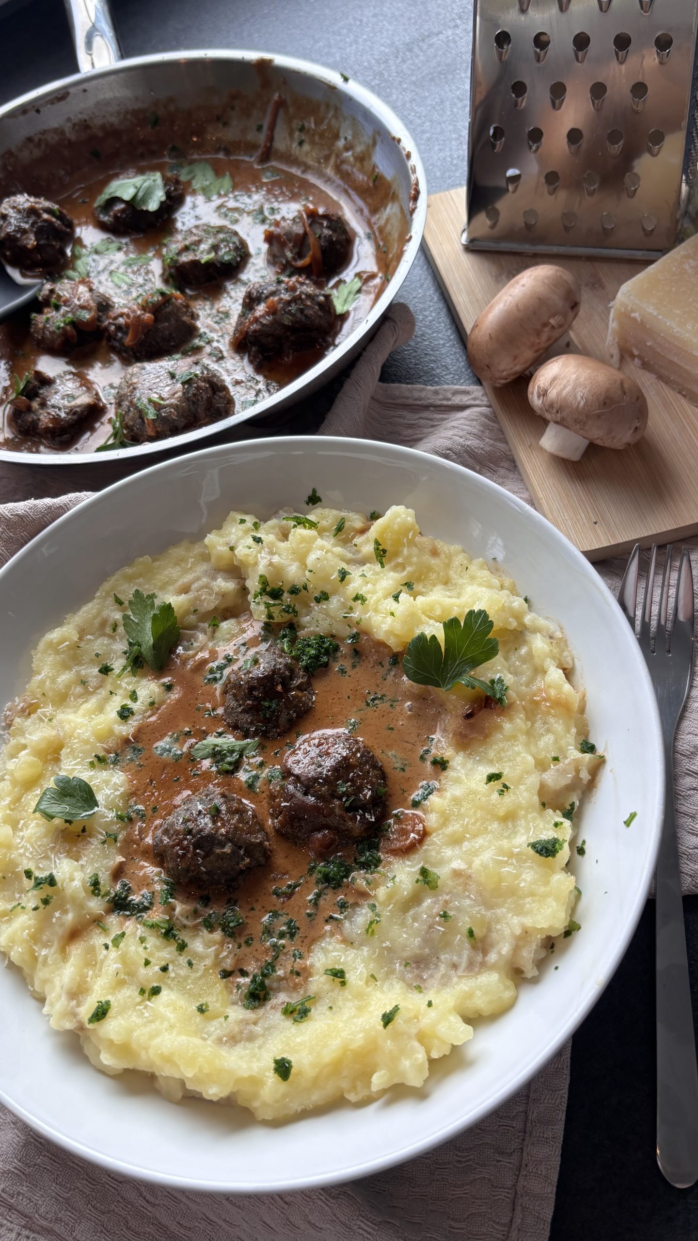 Vegetarische Hackbällchen aus Champignons in Rahmsoße mit Kartoffel-Parmesan-Püree und Petersilie.