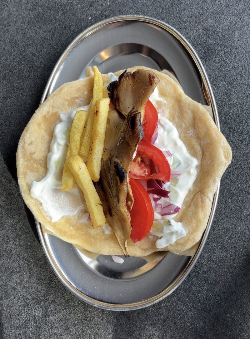 Gefülltes Pita-Brot mit gebratenen Austernpilzen, Pommes, Tomaten und Tzatziki.