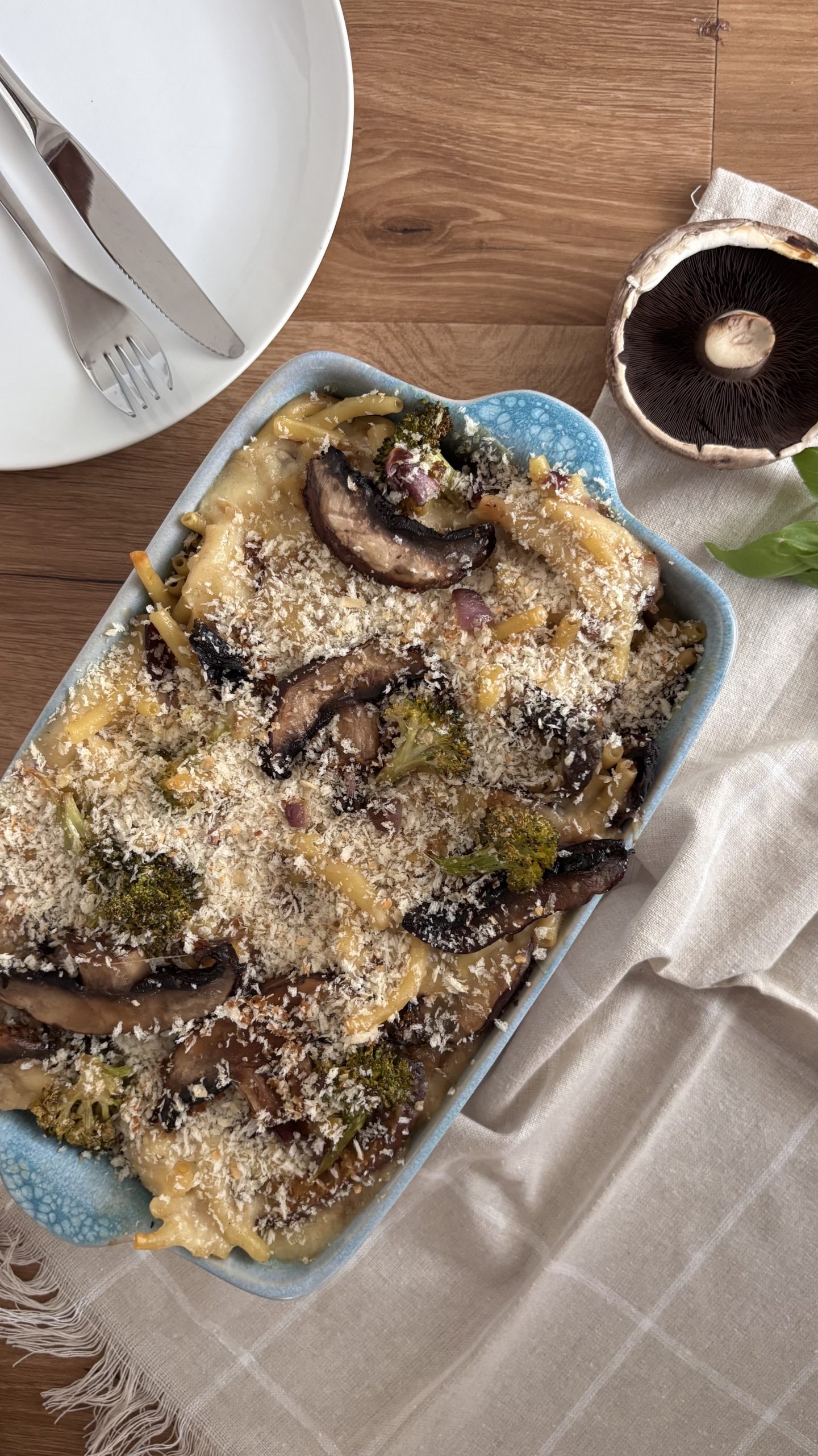 Cremiger Makkaroni-Auflauf mit gerösteten Portobello-Stücken, Brokkoli und goldbrauner Käse-Panko-Kruste in einer Auflaufform.