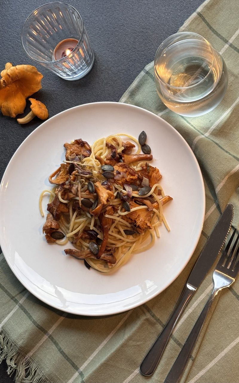 Spaghetti mit Pfifferlingen und Kürbiskernen herbstlich angerichtet.