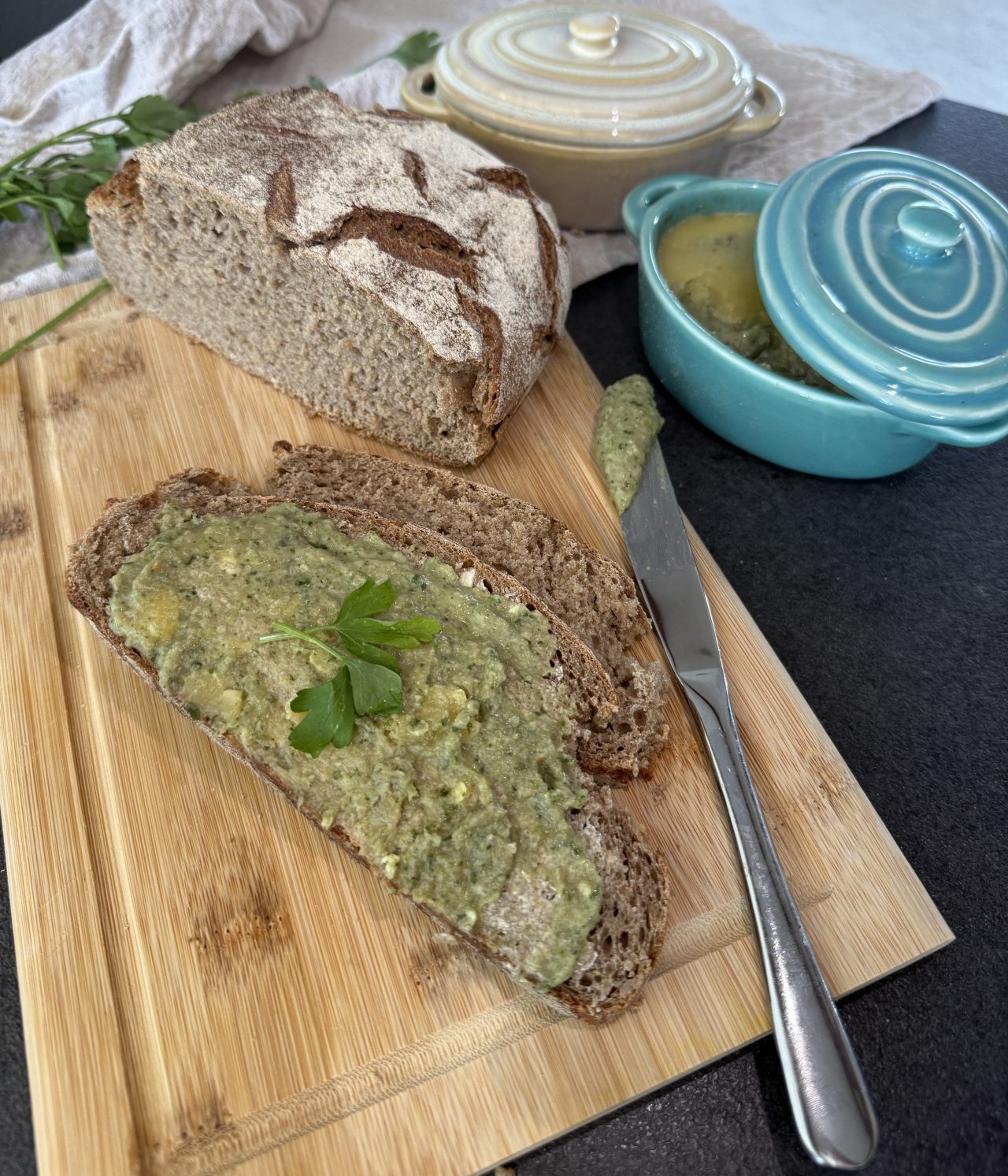 Veganer Austernpilz-Brotaufstrich im Glas, serviert auf geröstetem Brot mit Petersilie.