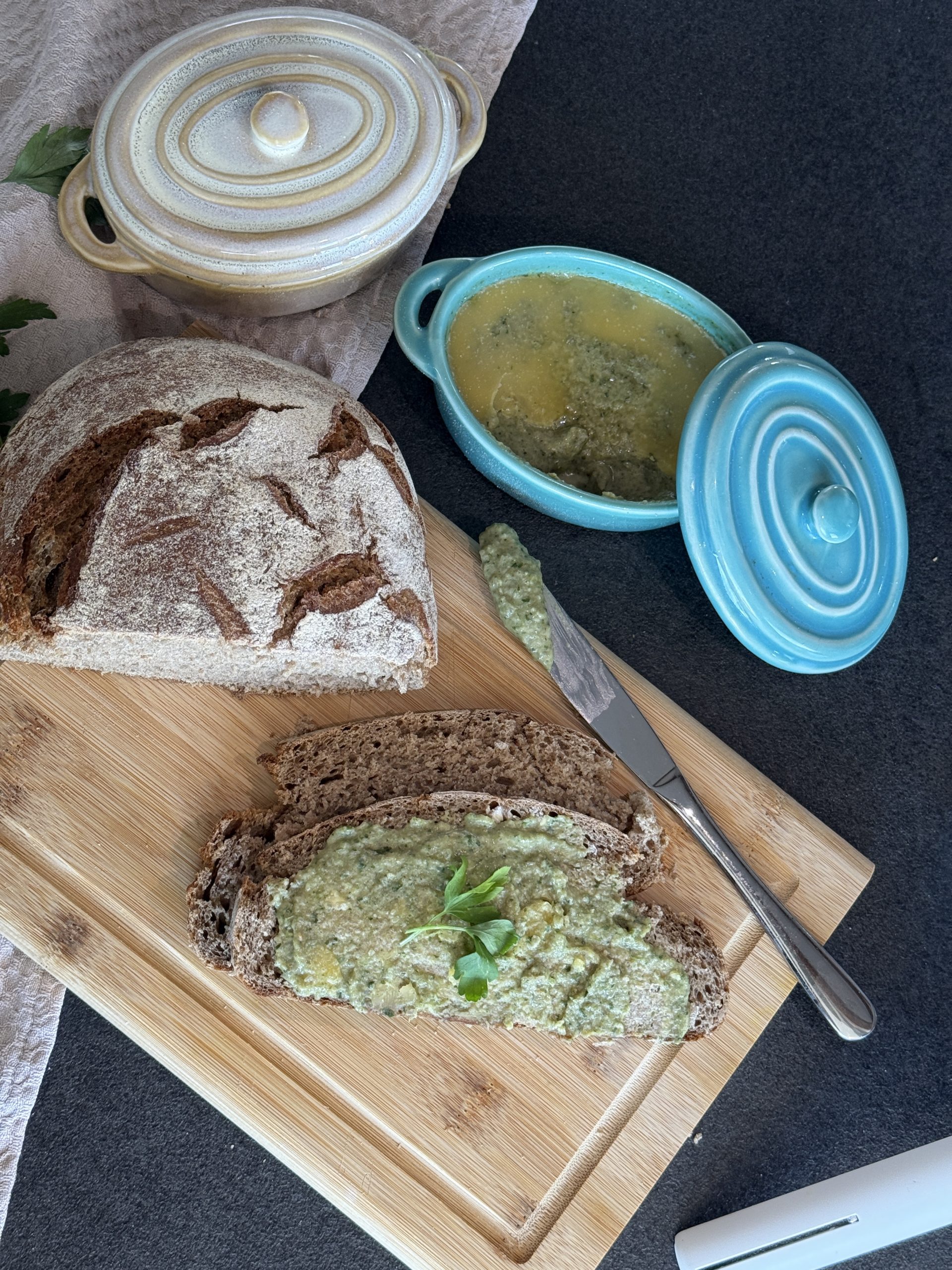 Veganer Austernpilz-Brotaufstrich im Glas, serviert auf geröstetem Brot mit Petersilie.
