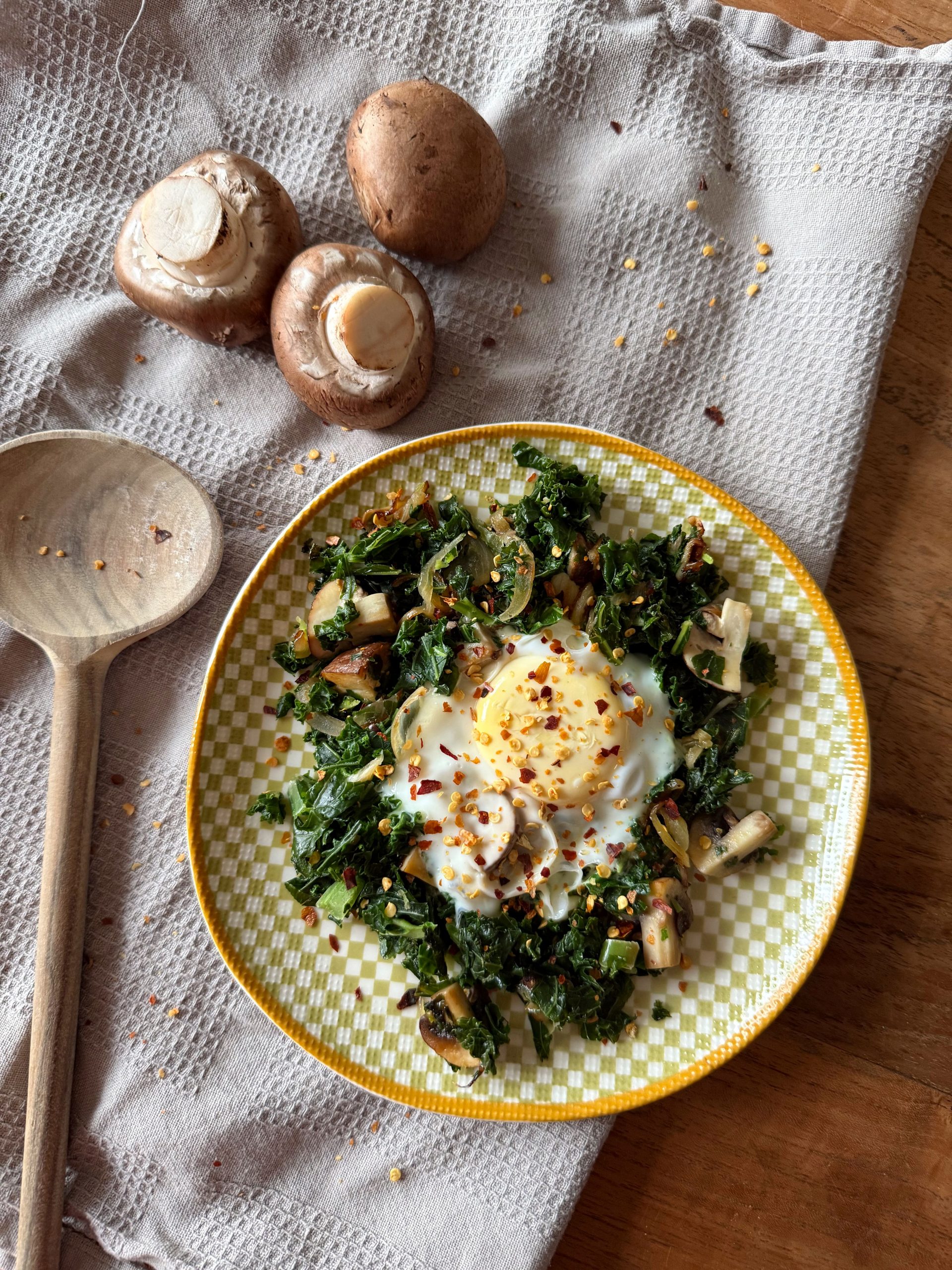 Grünkohl-Shakshuka mit Champignons und Ei, serviert direkt aus der Pfanne.